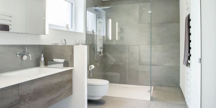 Ein modernes Badezimmer mit einer eleganten Dusche aus Glas und einem minimalistischen Waschbecken aus Holz und Weiß.